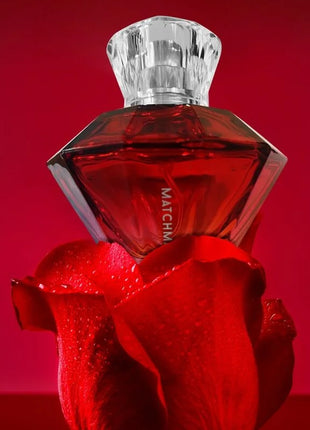 A red diamond-shaped pheromone perfume bottle auge der liebe matchmaker with faceted crystal stopper and match label