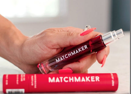Eine transparente rote roll-on glasflasche mit silberkappe und matchmaker schriftzug für auge der liebe pheromon parfum