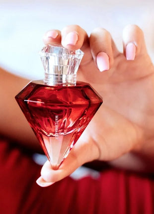 A vibrant red diamond-shaped pheromone parfum bottle auge der liebe with clear crystal stopper 30 ml