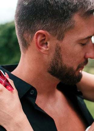 A vibrant red faceted crystal perfume bottle labeled matchmaker from auge der liebe pheromone parfum 30 ml