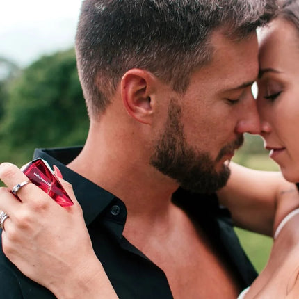 A vibrant red faceted crystal perfume bottle labeled matchmaker from auge der liebe pheromone parfum 30 ml