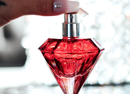 Ein leuchtend rotes, diamantförmiges parfumfläschchen auge der liebe matchmaker mit silberner spraydüse 30 ml