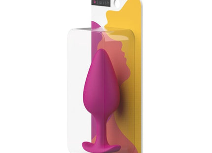 Ein lebendiger magentafarbener silikon-prostatastecker in klarer plastik- und bunter kartonverpackung von B SWISH