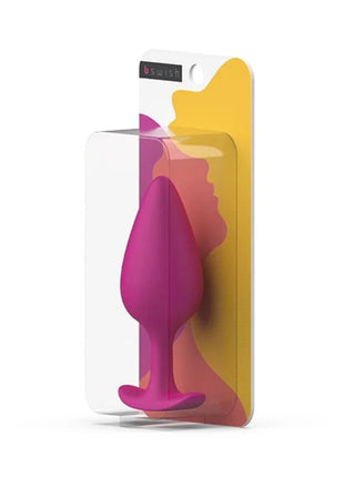 Ein lebendiger magentafarbener silikon-prostatastecker in klarer plastik- und bunter kartonverpackung von B SWISH