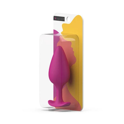 Ein lebendiger magentafarbener silikon-prostatastecker in klarer plastik- und bunter kartonverpackung von B SWISH