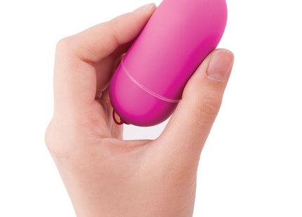 Eine vibrant pinke, glattoberfläche eiförmige vibrator von b swish bnaughty unleashed klassische rosa fernbedienung in hand gehalten