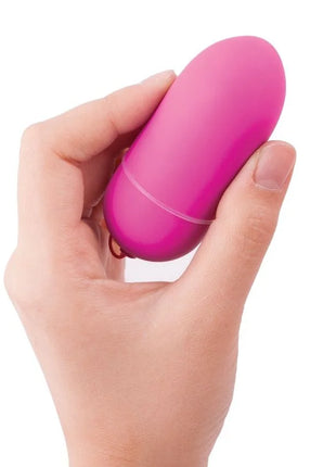 Eine vibrant pinke, glattoberfläche eiförmige vibrator von b swish bnaughty unleashed klassische rosa fernbedienung in hand gehalten
