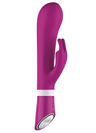 Ein schlanker, lebhafter magentafarbener b swish bwild deluxe bunny rabbit vibrator aus silikon mit weißem steuerband nahe dem stiel