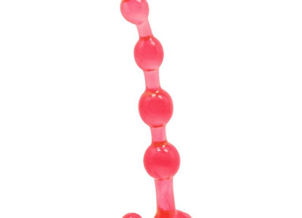 Ein transparenter rosa silikon analplug mit einer reihe abgerundeter perlen und einem breiten stützfuß von baile bendy twist rote analblle