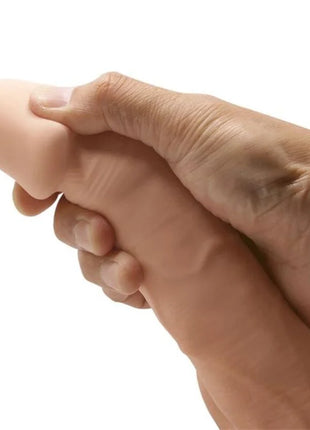 Eine realistische, fleischfarbene silicone dildo 21,8 cm von baile in einer hand gehalten