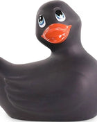 Schwarze gummiente mit leuchtend blauen augen und orangefarbenem schnabel von big tease toys ich rubbe meine duckie classic vibrierend