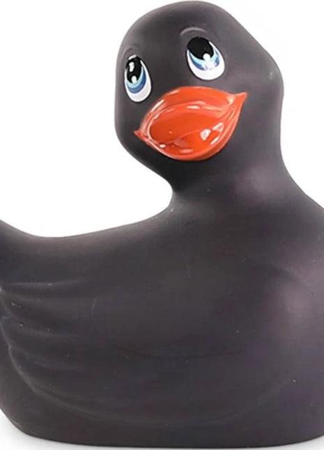 Schwarze gummiente mit leuchtend blauen augen und orangefarbenem schnabel von big tease toys ich rubbe meine duckie classic vibrierend