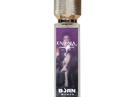Ein rechteckiges glasflakon enigma eau de parfum von born woman mit strukturiertem goldverschluss und lila etikett