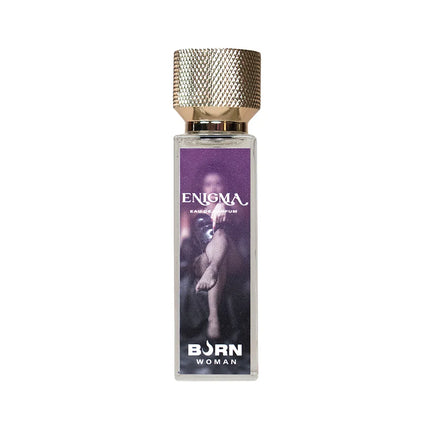 Ein rechteckiges glasflakon enigma eau de parfum von born woman mit strukturiertem goldverschluss und lila etikett