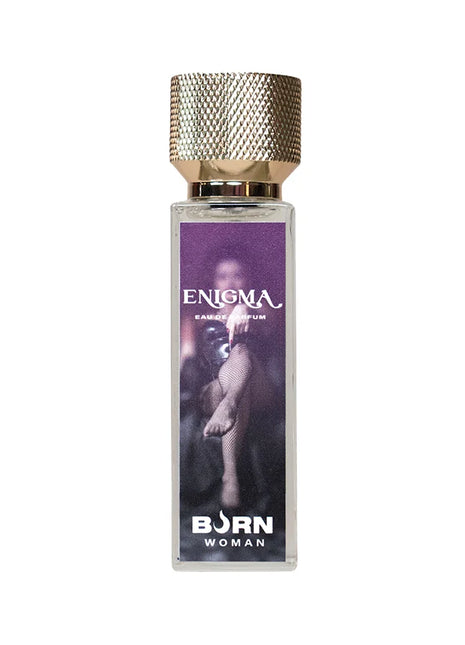 Ein rechteckiges glasflakon enigma eau de parfum von born woman mit strukturiertem goldverschluss und lila etikett