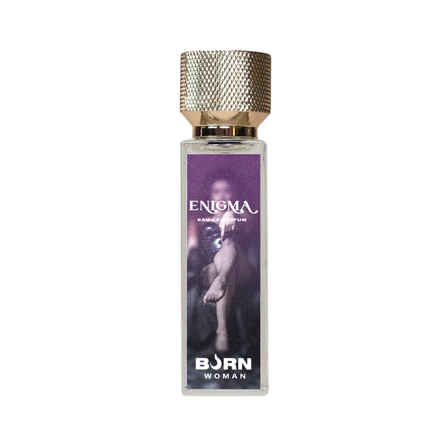 Ein rechteckiges glasflakon enigma eau de parfum von born woman mit strukturiertem goldverschluss und lila etikett
