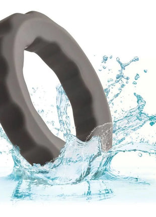 Ein schlanker, dunkelgrauer silikonring mit strukturierter, wellenförmiger außenkante von calexotics alpha erect ring grau
