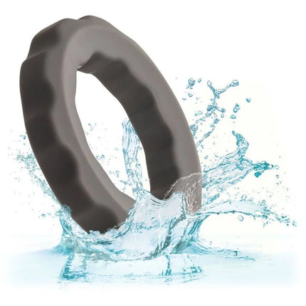 Ein schlanker, dunkelgrauer silikonring mit strukturierter, wellenförmiger außenkante von calexotics alpha erect ring grau