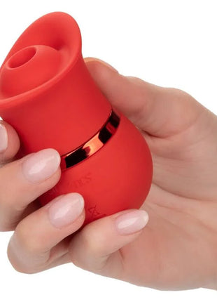 Ein lebhaft roter silikonvibrator in rosenform mit schlankem metallischem akzentband aus dem calexotics french kiss suck & play set