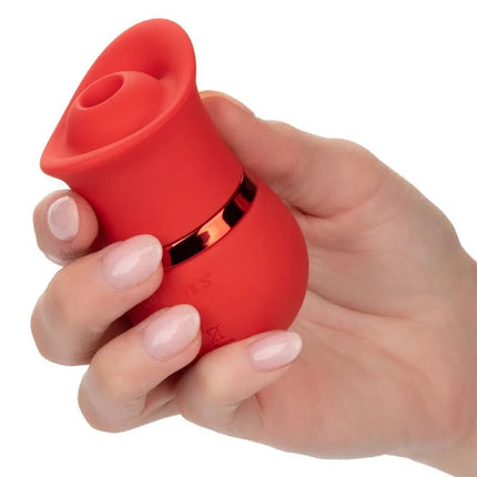 Ein lebhaft roter silikonvibrator in rosenform mit schlankem metallischem akzentband aus dem calexotics french kiss suck & play set