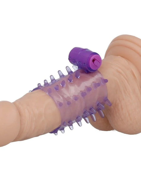 Ein lilafarbener und hautfarbener silikonvibrator mit strukturierter, stacheliger oberfläche und steuerungstaste