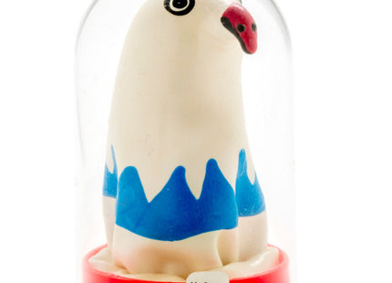 Eine weiße keramikfigur eines stilisierten vogels mit blauen bergähnlichen mustern und rotem schnabel unter einer glaskuppel auf rotem sockel aus der serie condenserie handbemalte neuheitskondome adler