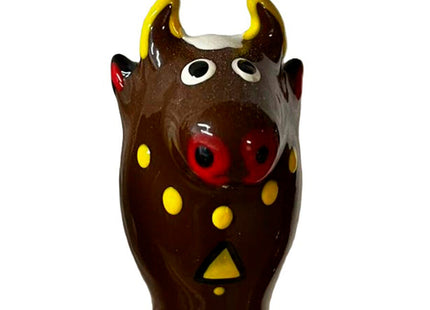 Glänzende braune keramik bullfigur mit gelben hörnern roter nase und dekorativen gelben punkten für condomerie kondome