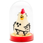 Eine handbemalte neuheitskondome cocky rooster figurine in creme mit schwarzen punkten und rotem kamm unter glaskuppel