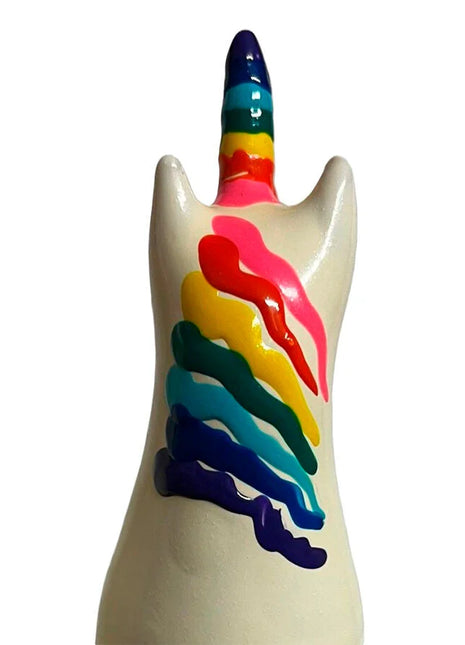 Glänzende weiße keramik-einhornfigur mit regenbogenfarbigem horn und mehrfarbigen farbstreifen auf dem rücken