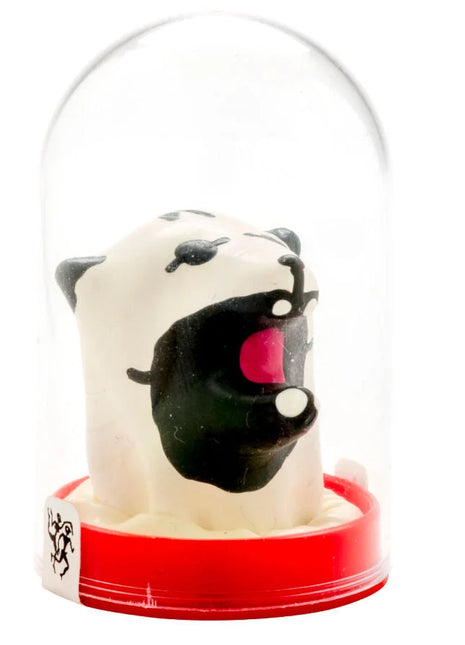 Weißer und schwarzer cartoon eisbär mit rosa zunge in klarer glaskuppel auf rotem kunststoffsockel aus condomerie handbemalt