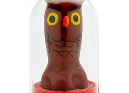 Eine braune schokoladeneulenfigur mit gelben augen und schwarzer gesichtszeichnung in einer klaren glaskuppel von condomerie