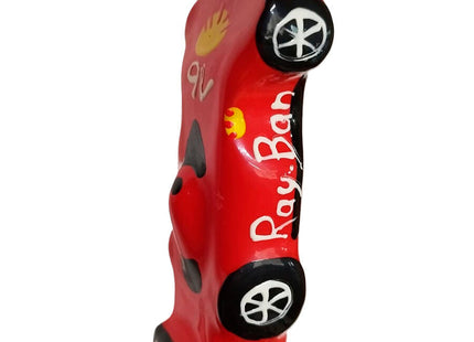 Ein lebhaft rotes, glänzendes keramisches auto förmiges figürchen mit handbemalten ray-ban details aus condomerie neuheitskondome f1 ferrari xl