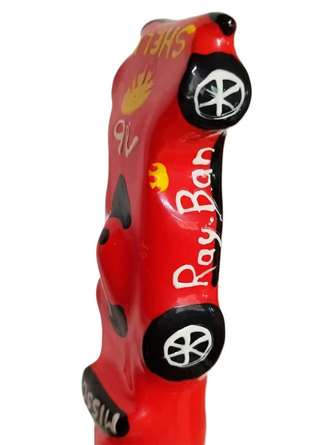 Ein lebhaft rotes, glänzendes keramisches auto förmiges figürchen mit handbemalten ray-ban details aus condomerie neuheitskondome f1 ferrari xl