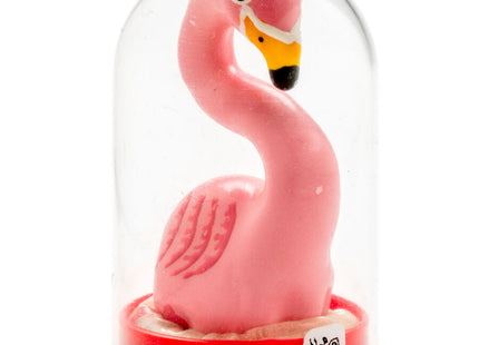 Eine pinke plastik flamingo figurine mit gelbem und schwarzem schnabel in einer klaren glaskuppel auf rotem sockel