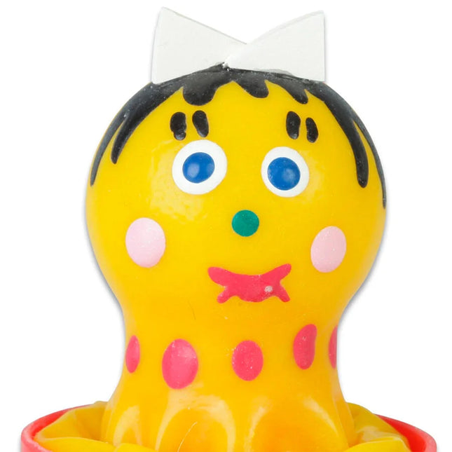 Gelbe plastikspielzeugfigur mit schwarzen haaren blauen augen rosa wangen und punkten im condomerie handbemalte kondome für mädchen