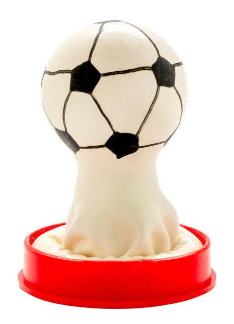 Eine weiße fußballförmige gummistempel mit schwarzen pentagon- und hexagon-patches auf rotem kunststofffuß für condomerie handbemalte neuheitskondome fußball