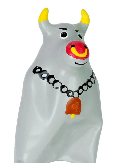 Graue glasfigur eines stiers mit gelben hörnern roter und gelber nase schwarzen augendetails und schwarzer kette mit orangefarbenem glöckchen aus der condomerie handbemalte neuheitskondome modell xl