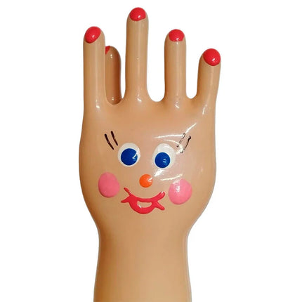Eine fröhliche beige plastikhand mit roten nägeln und bemaltem gesicht auf handbemalte neuheitskondome xl