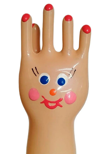 Eine fröhliche beige plastikhand mit roten nägeln und bemaltem gesicht auf handbemalte neuheitskondome xl