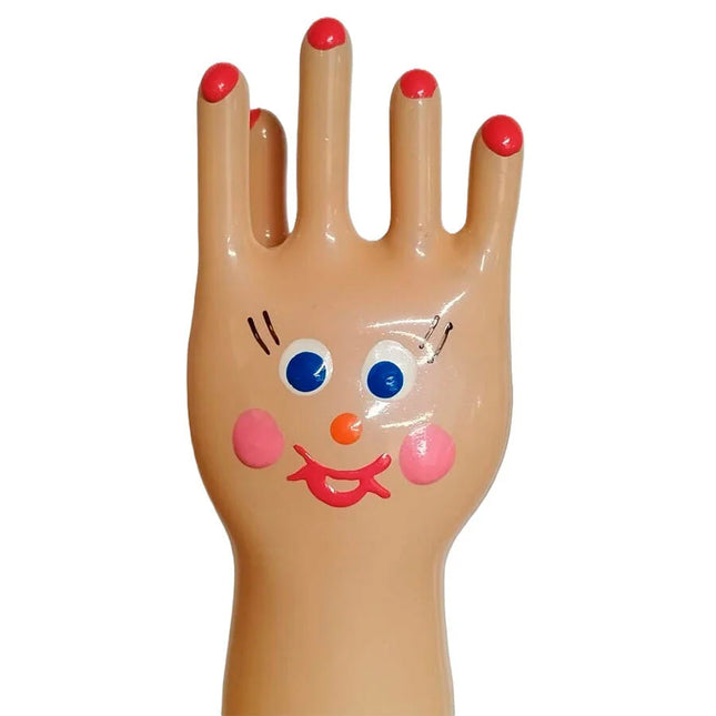 Eine fröhliche beige plastikhand mit roten nägeln und bemaltem gesicht auf handbemalte neuheitskondome xl