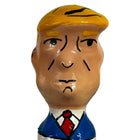 Ein glänzendes keramikfigürchen mit stylisiertem männlichen kopf, blonden haaren, blauem anzug und roter krawatte aus condomerie handbemalte neuheitskondome grumpy trump xl