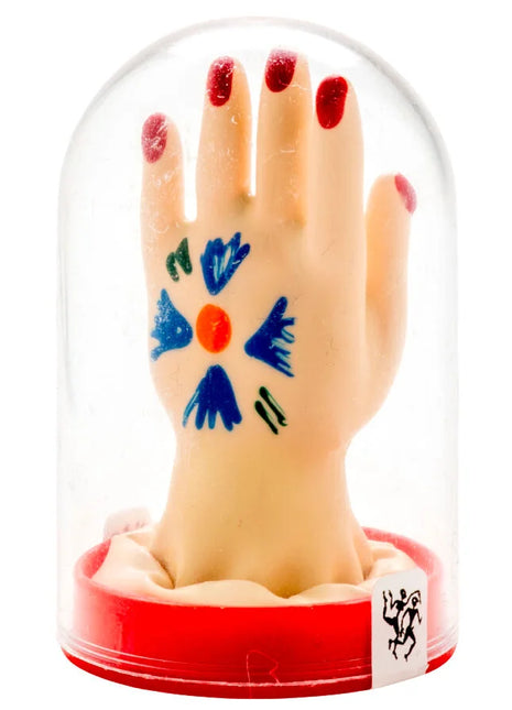 Beige handmodell mit rotem nagellack und farbenfrohem design auf der handfläche in klarglasglocke