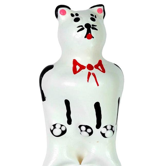 Weiße keramik katzenfigur mit schwarzen akzenten rosa ohren und nase roter schleife und pfotenabdrücken auf dem bauch