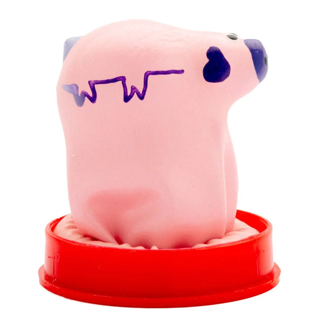 Pink stressball in schweineform mit lila linie und schwarzem herz auf rotem plastiksockel von condomerie