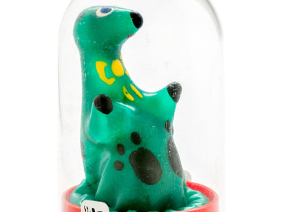 Eine grüne, gefleckte dinosaurierfigur mit gelben markierungen und schwarzen augen in einer klaren glaskuppel auf rotem sockel aus der condomerie handbemalte neuheitskondome loch ness monster serie