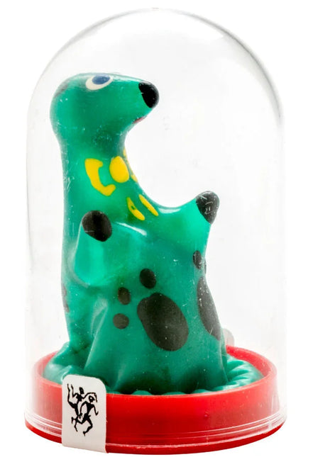 Eine grüne, gefleckte dinosaurierfigur mit gelben markierungen und schwarzen augen in einer klaren glaskuppel auf rotem sockel aus der condomerie handbemalte neuheitskondome loch ness monster serie