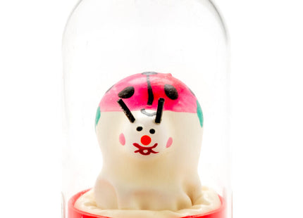 Eine handbemalte, cremefarbene marienkäfer-kondomfigur mit rosa-grünem kopfschmuck in einer glaskuppel von condomerie