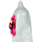 Translucente weiße kerze in kondomform mit handbemaltem pink-schwarz-gelbem cartoonmotiv bei condomerie motorrad xl