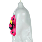 Translucente weiße kerze in kondomform mit handbemaltem pink-schwarz-gelbem cartoonmotiv bei condomerie motorrad xl