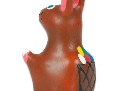 Braune keramik-osterhasenfigur mit rosa ohren und pfoten blaue augen schwarzer nase bemalter korb mit bunten pinseln